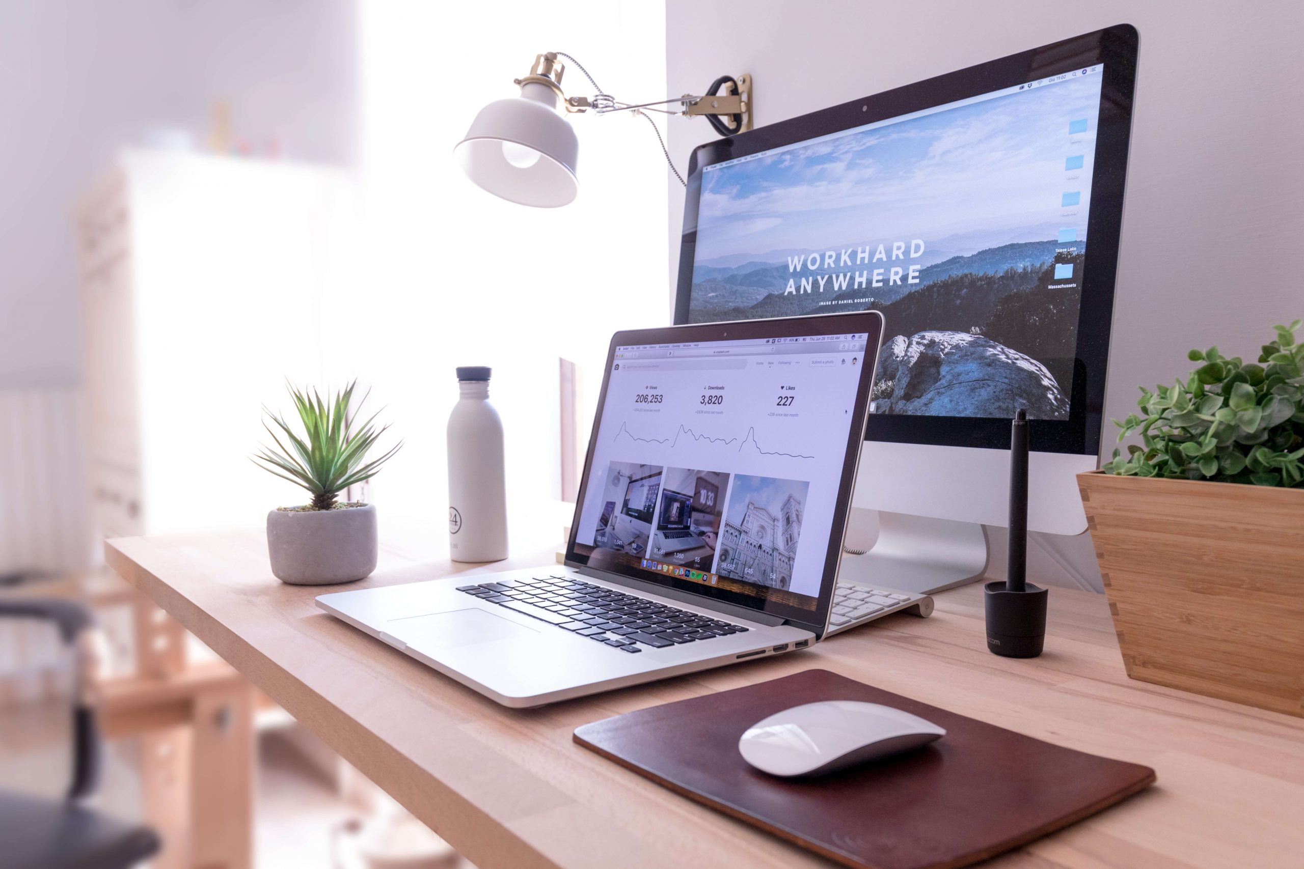 Modern workspace with a laptop and dual monitors on a wooden desk.