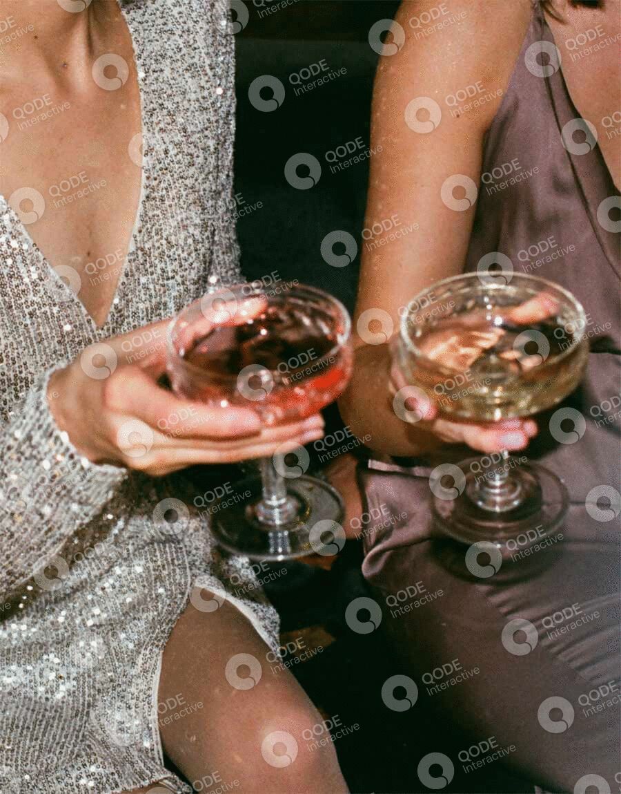 Two people holding glasses of champagne in elegant attire.