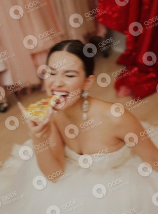 Bride enjoying a slice of pizza with a playful smile.
