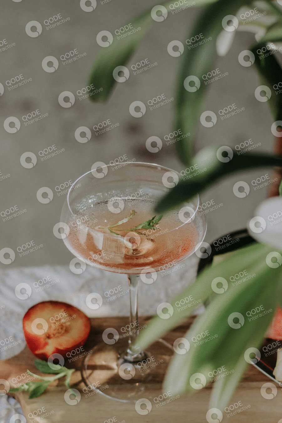 A cocktail glass with strawberries and a garnish on top.