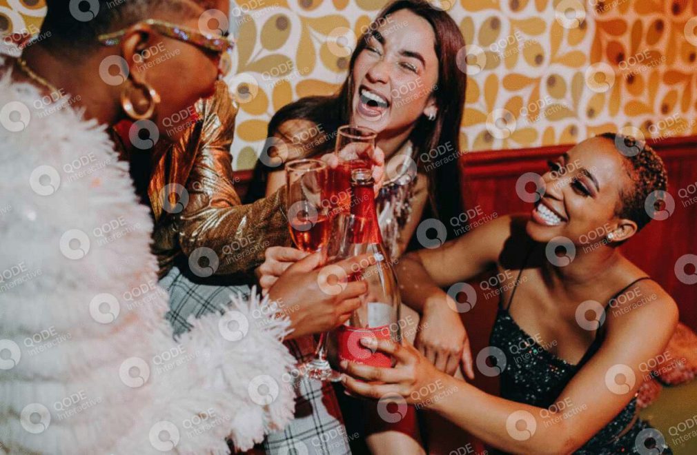 Friends joyfully clinking glasses at a lively party.