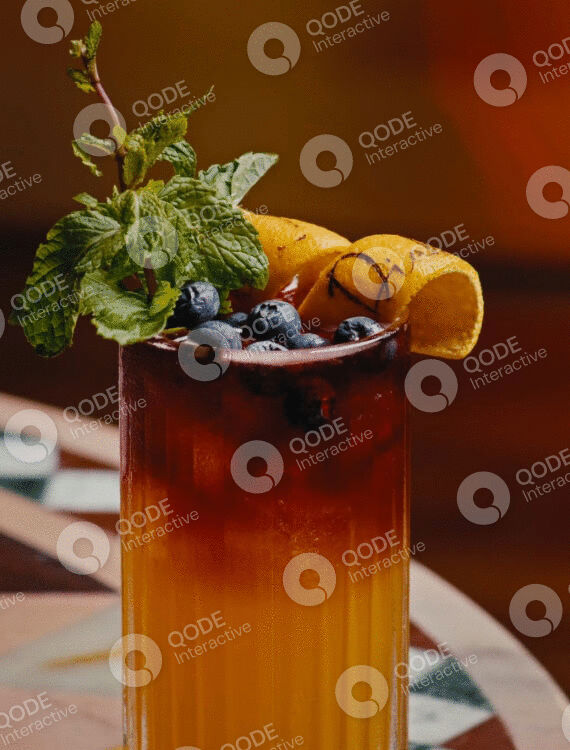 Refreshing iced tea garnished with blueberries, orange slices, and mint leaves.
