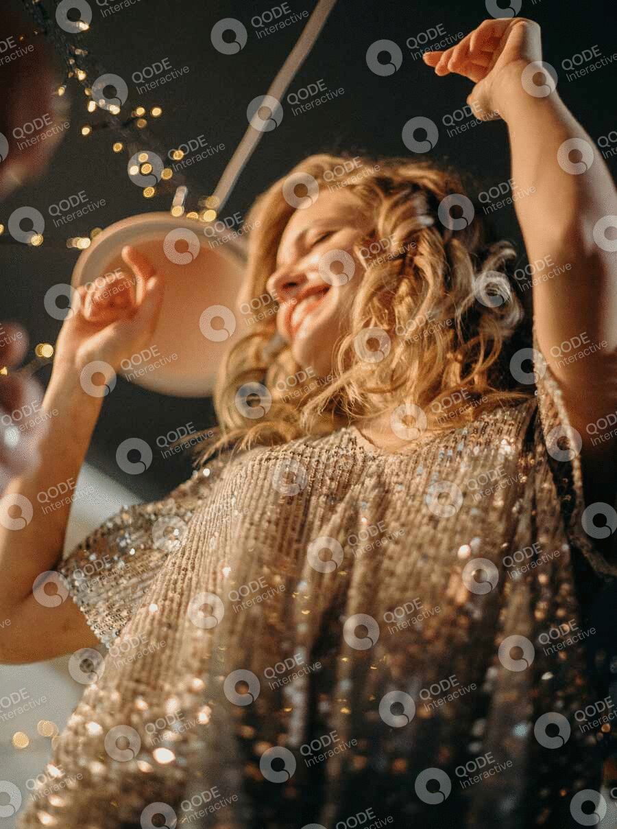 Woman joyfully dancing with golden light and bubbles around her.
