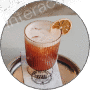 A frothy iced coffee with a dried citrus garnish on a saucer.