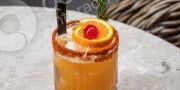 A tropical cocktail garnished with an orange slice and cherry.