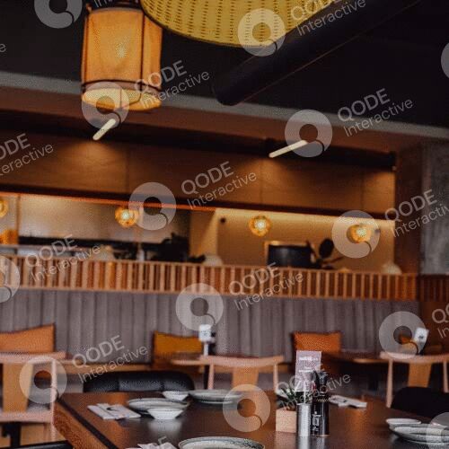 Cozy Japanese restaurant interior with wooden tables and warm lighting.