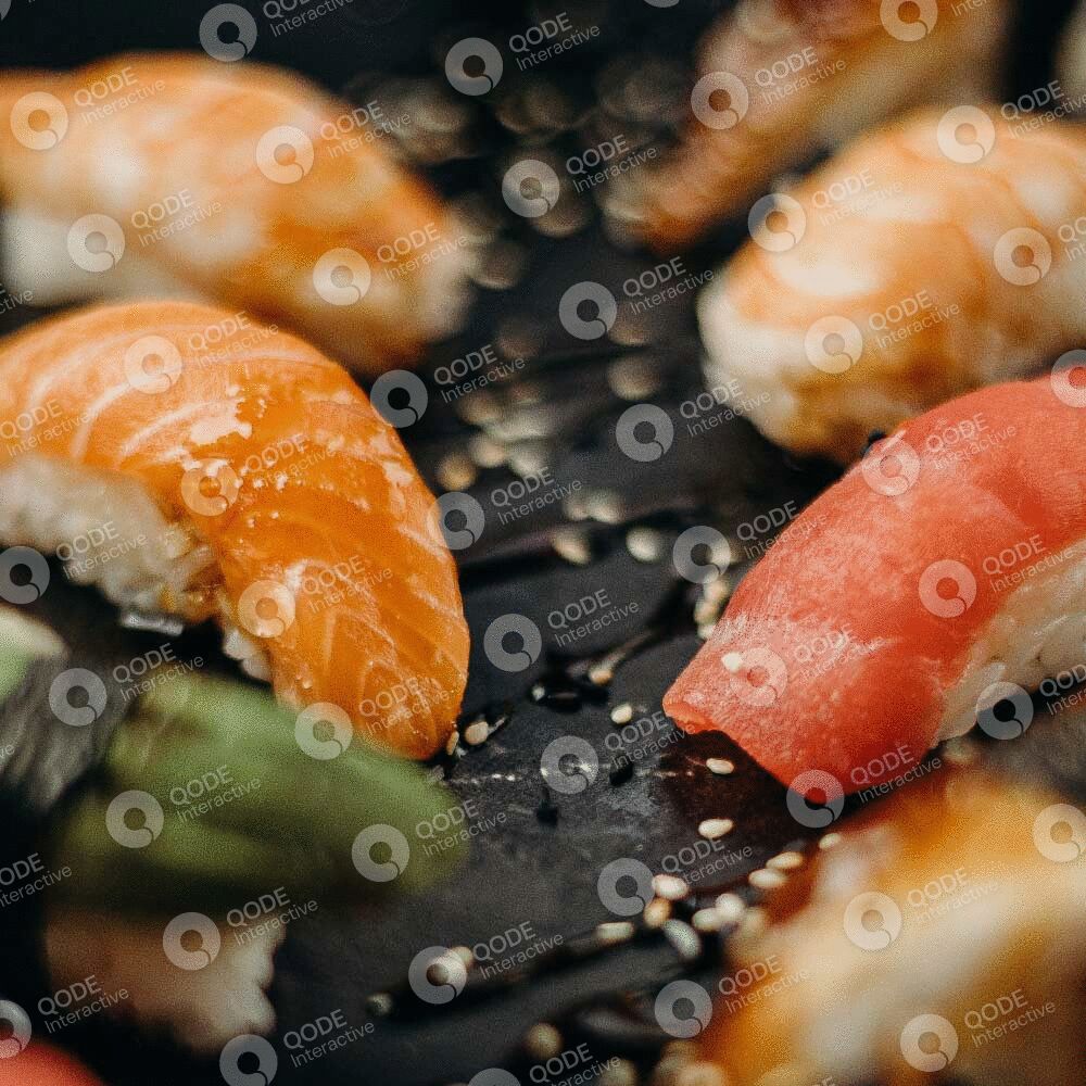Close-up of assorted sushi pieces with salmon and tuna on a plate.