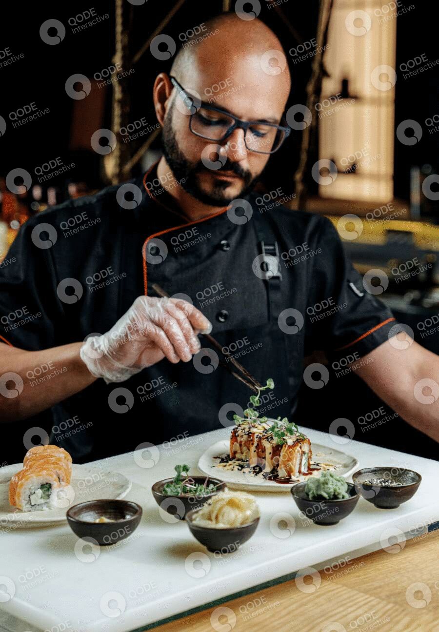 Chef plating a gourmet dish with precision in a professional kitchen.