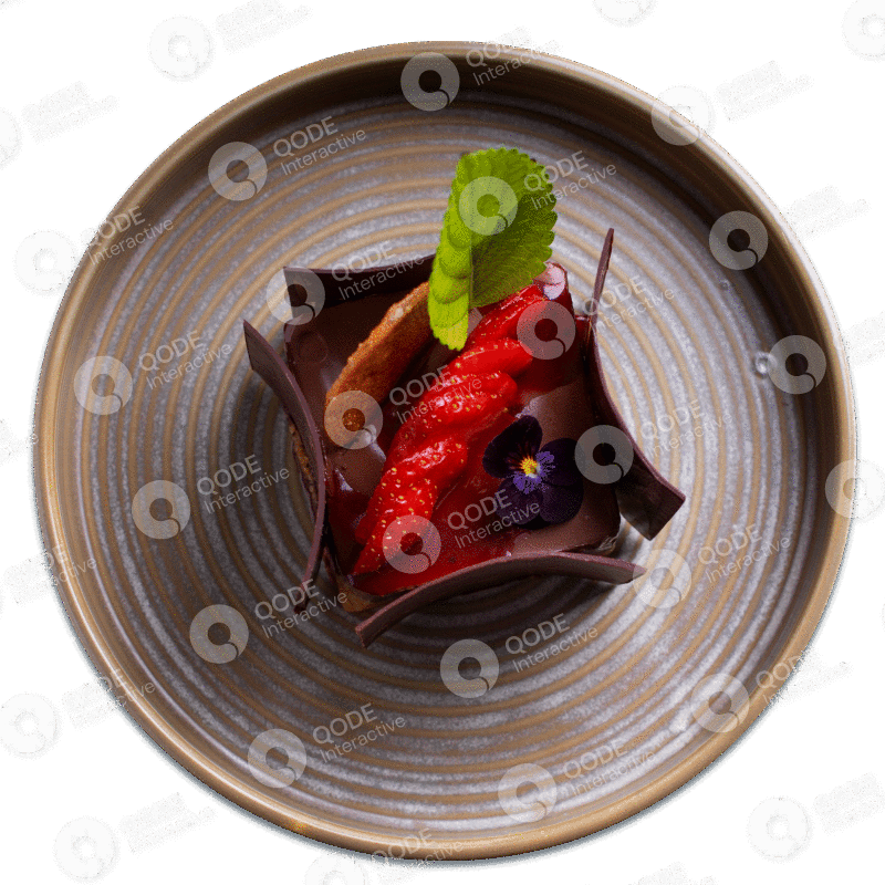 Elegant chocolate dessert garnished with strawberries and mint leaves on a ceramic plate.