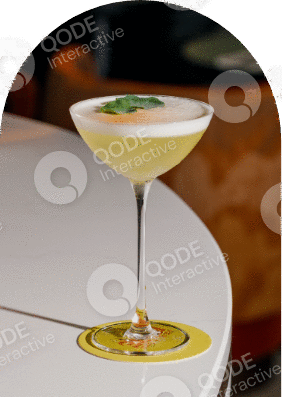 Elegant cocktail with a frothy top and lime garnish in a martini glass.