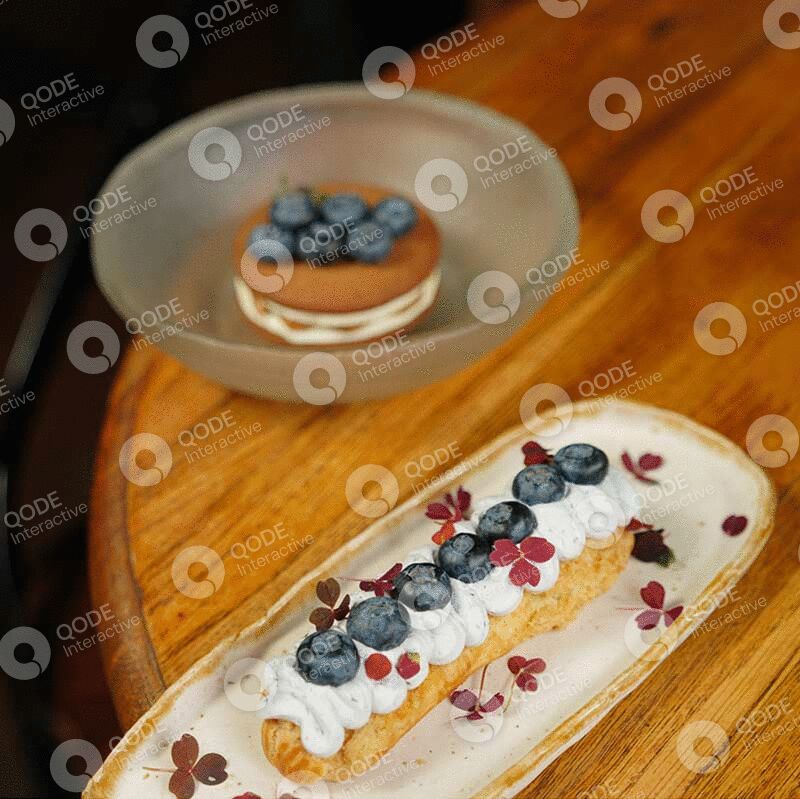 A blueberry tart and a dessert with cream and blueberries on a wooden table.