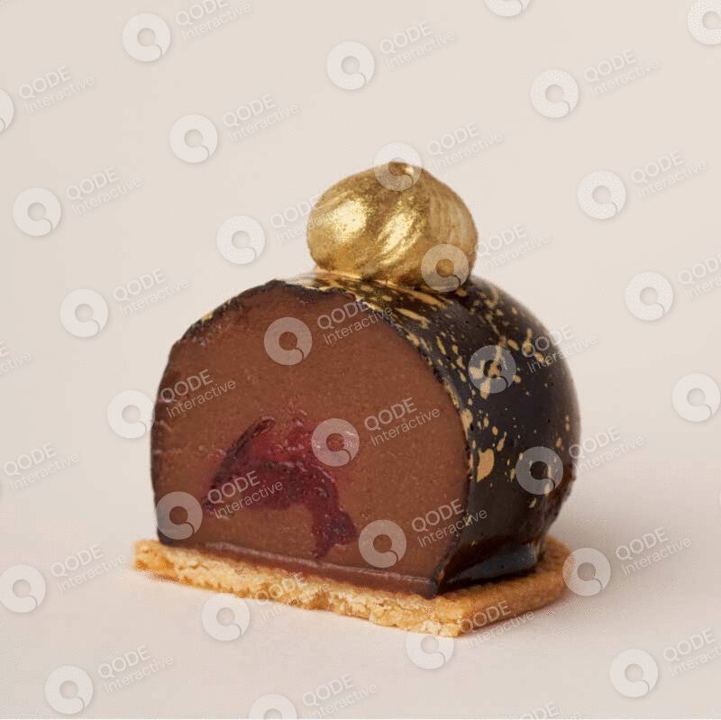 Chocolate dessert roll with gold decoration on a wooden base.