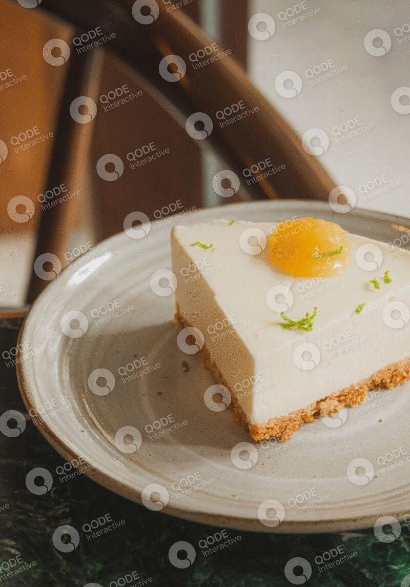 A slice of cheesecake garnished with a small egg yolk and lime zest on a plate.