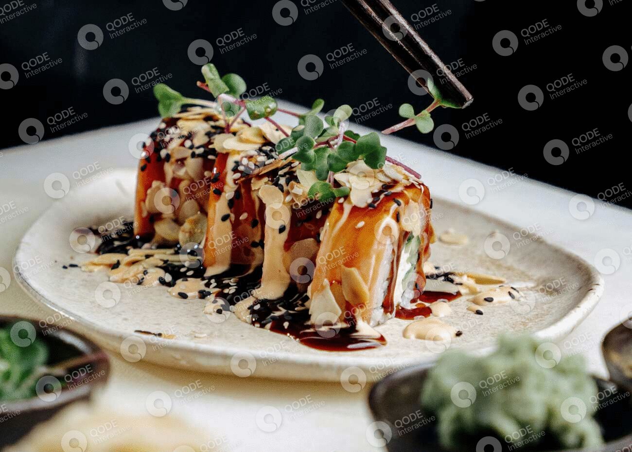 Delicious sushi rolls drizzled with sauce and garnished with sesame seeds and greens.