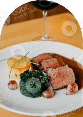 Elegant plated dish with sliced meat, spinach, and potato gratin.