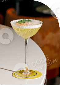 Elegant cocktail in a coupe glass garnished with herbs.