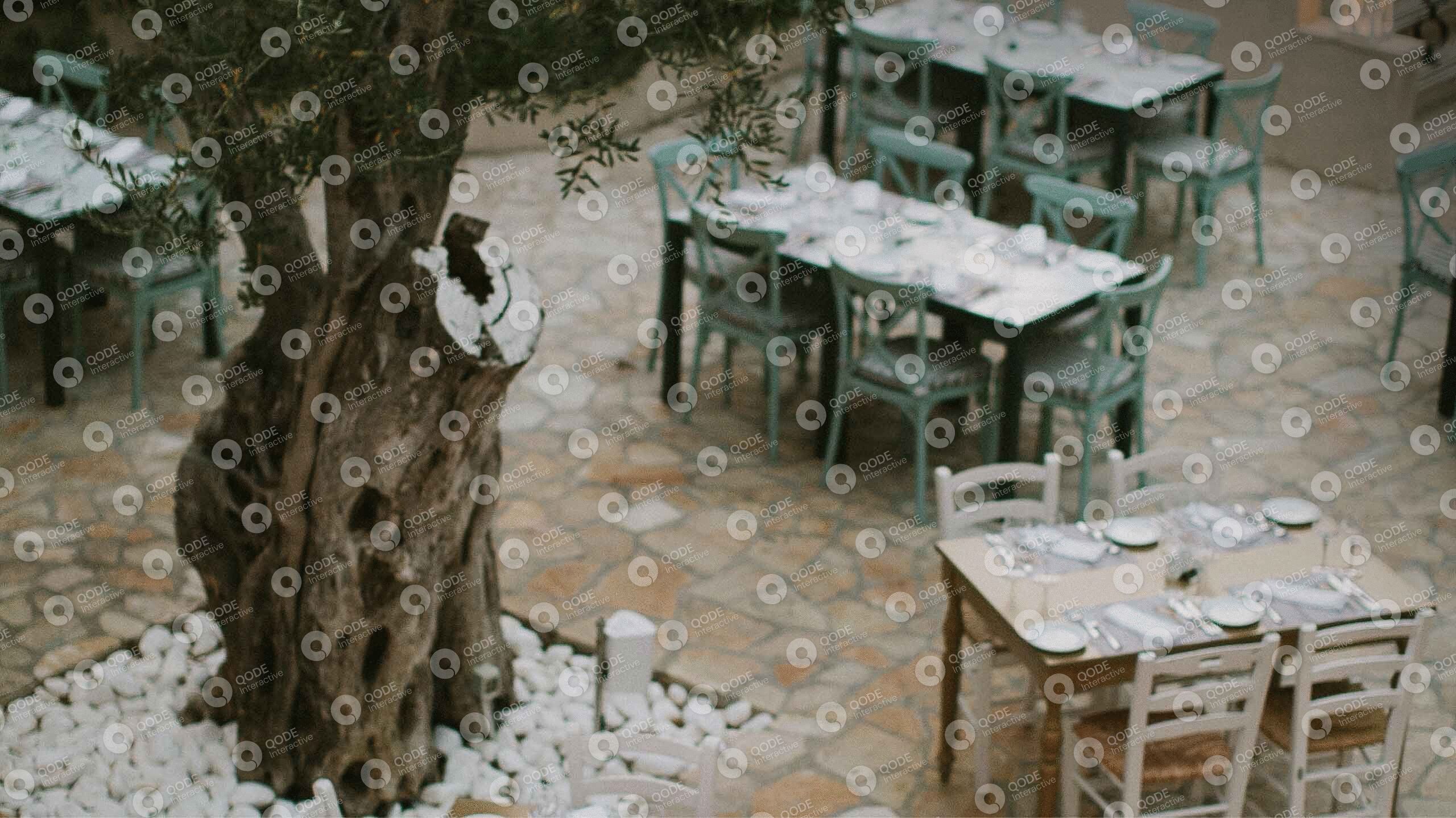 Rustic outdoor dining area with wooden tables and chairs.