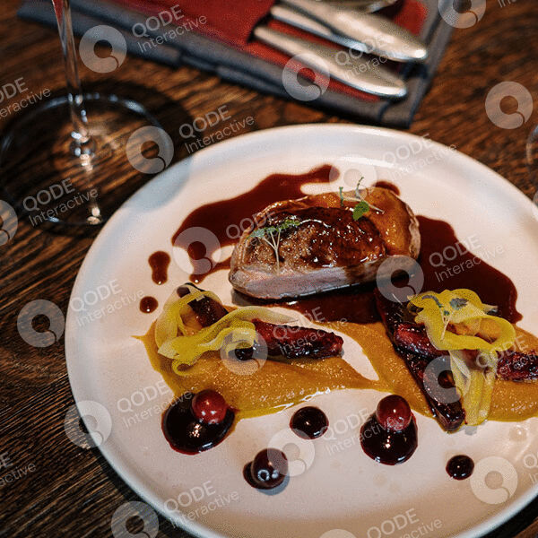 Gourmet steak with colorful sauces and decorative plating on a white plate.