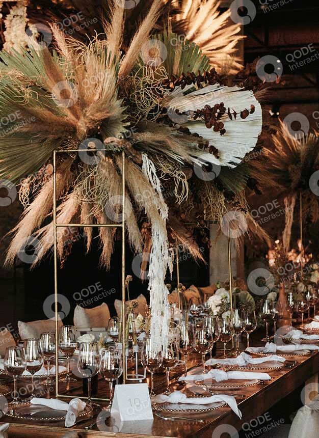 Rustic boho wedding table decor with dried flowers and candles.
