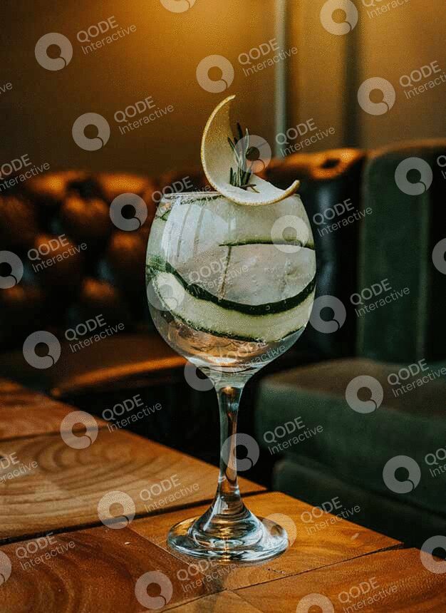 A glass with layered dessert and a chocolate piece on top.