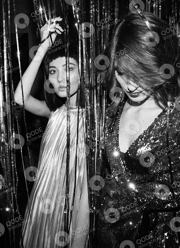 Two women dancing at a lively party with dynamic lighting and motion.