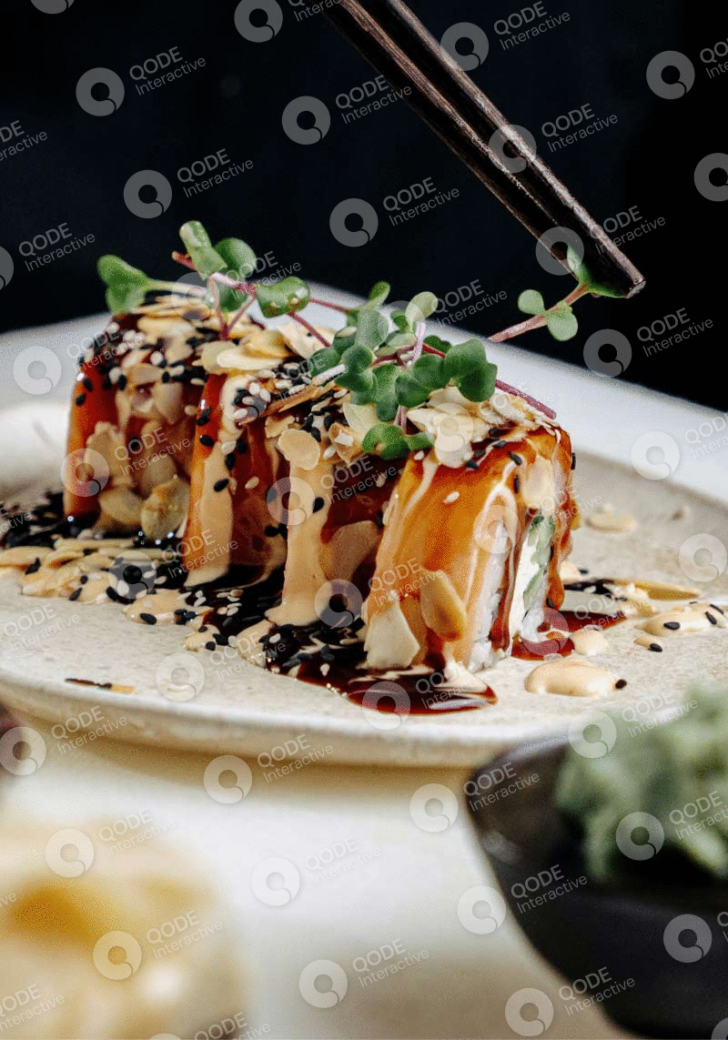 Delicious sushi roll drizzled with sauces and garnished with herbs and sesame seeds.