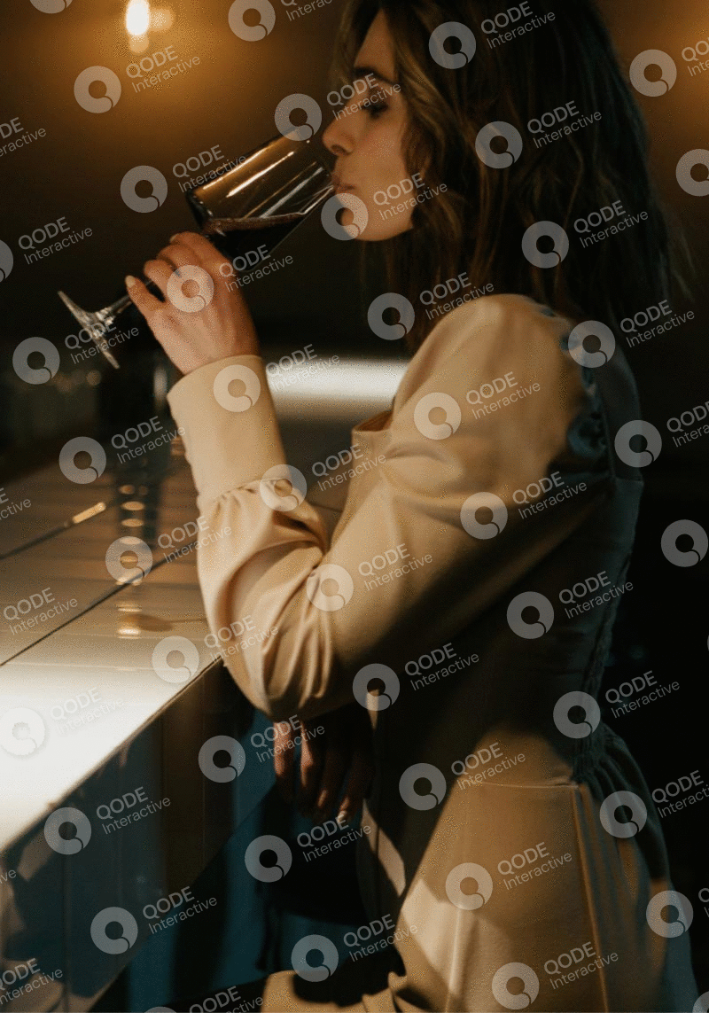 Woman adjusting her glasses while wearing a beige blazer.