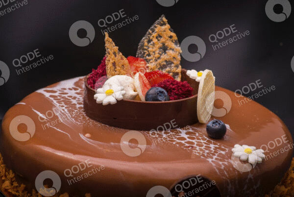 Elegant chocolate dessert with fresh berries and decorative elements.