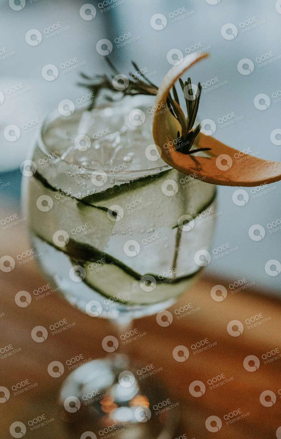 A refreshing glass of cucumber-infused water with a decorative straw.