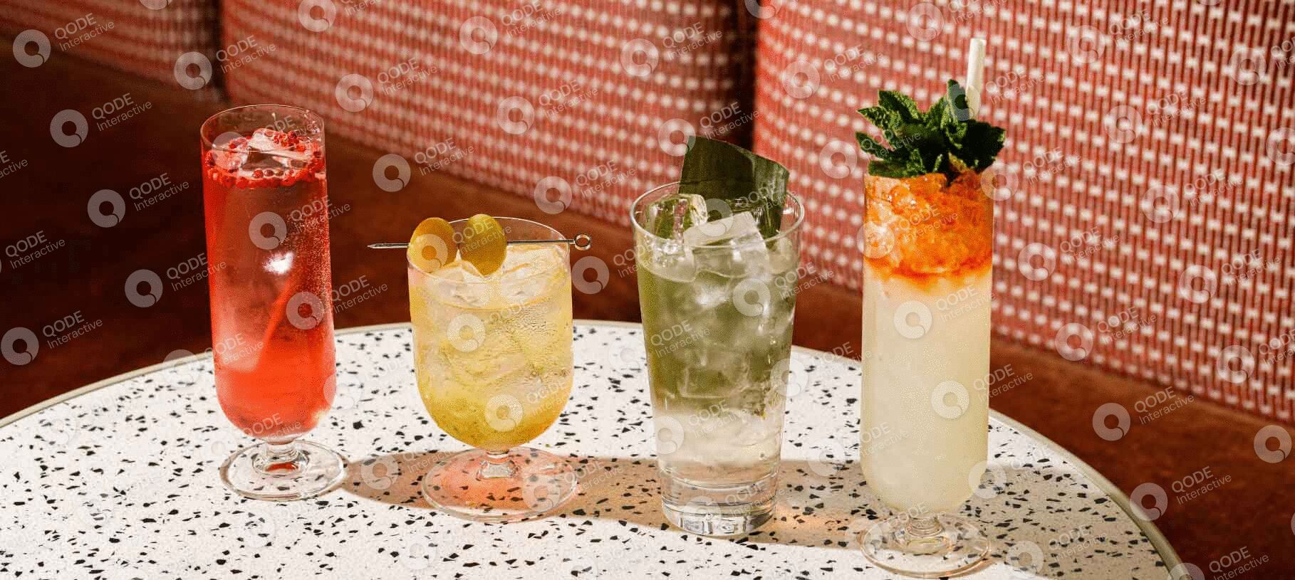 Three refreshing cocktails with different garnishes on a terrazzo table.