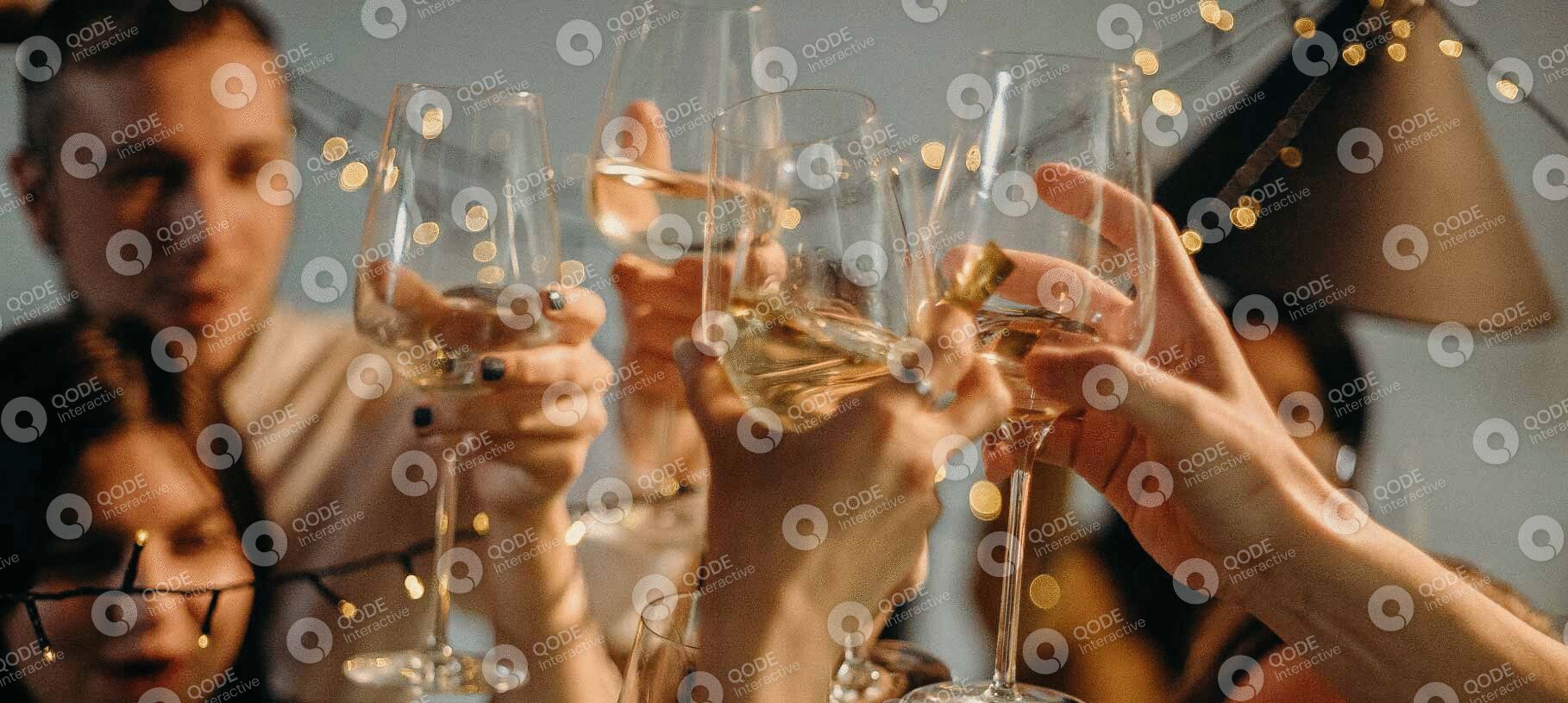 Hands clinking champagne glasses in celebration with sparkling bubbles.