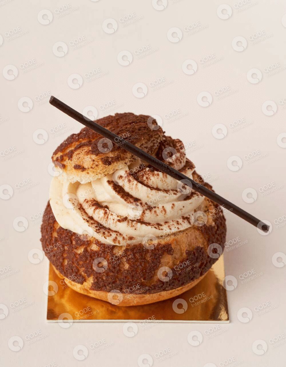 A creamy dessert topped with cocoa powder and a chocolate stick.