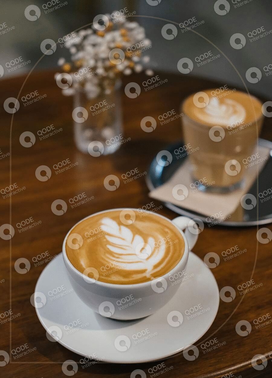 Two cups of latte with beautiful foam art on wooden table.