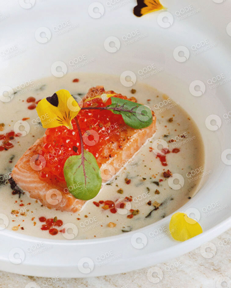 Gourmet salmon dish with creamy sauce and garnishes.