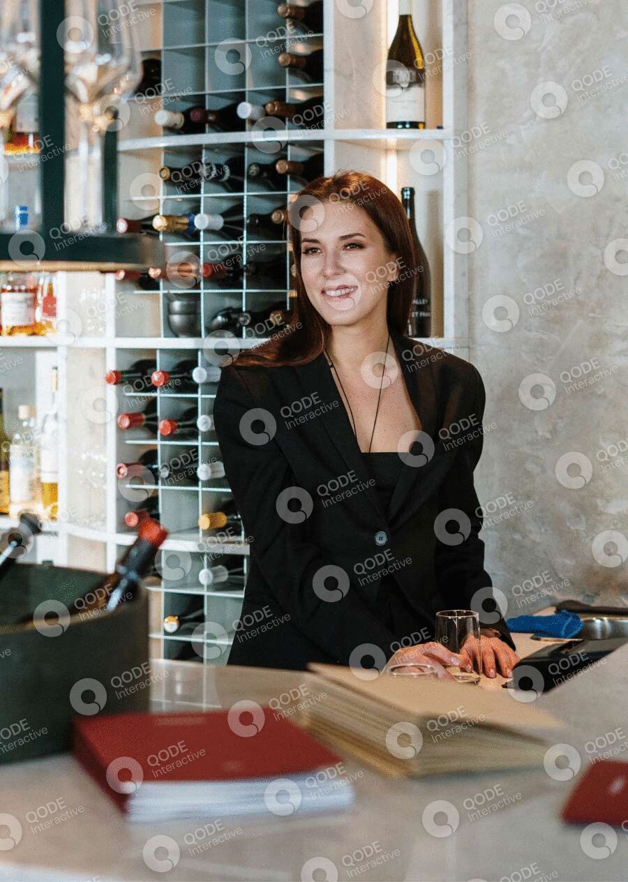 Confident woman standing behind a counter in a modern store.