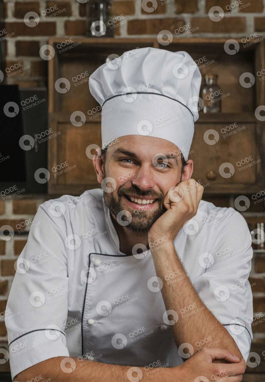 Smiling male chef in white uniform and hat posing thoughtfully.