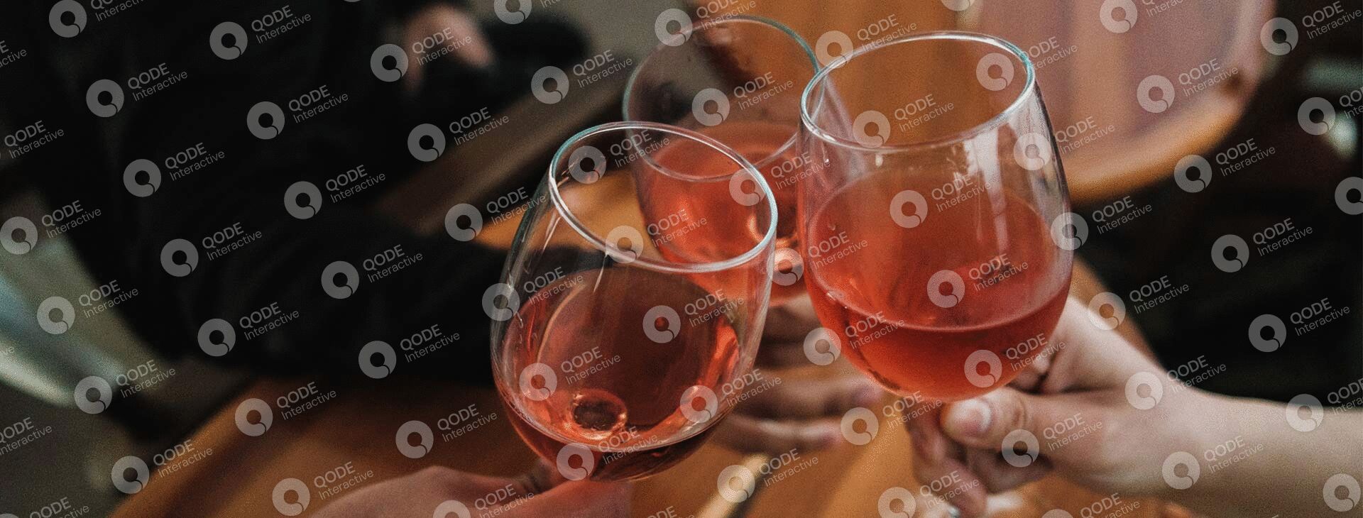 Two glasses of rosé wine on a rustic wooden table.