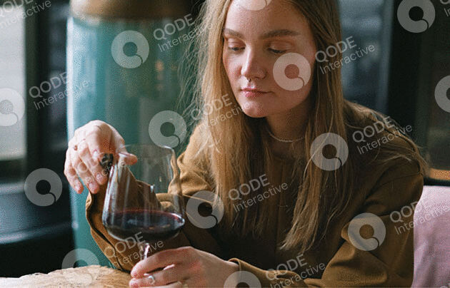 A woman pours wine into a glass at a cozy setting.