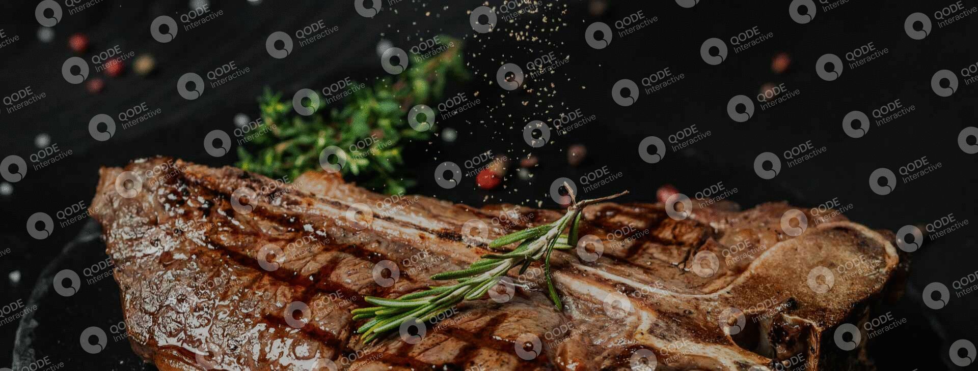 Fresh rosemary sprig resting on rustic wood outdoors.