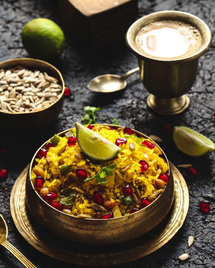 A bowl of vibrant Indian biryani garnished with lemon and pomegranate seeds.